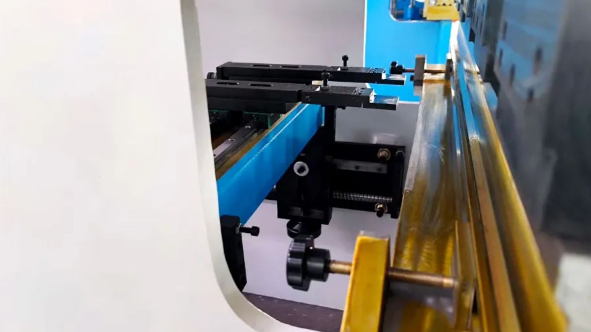 "Cận cảnh bộ gá kẹp và bàn chặn sau của máy chấn tôn CNC, hỗ trợ định vị và gia công kim loại tấm chính xác."