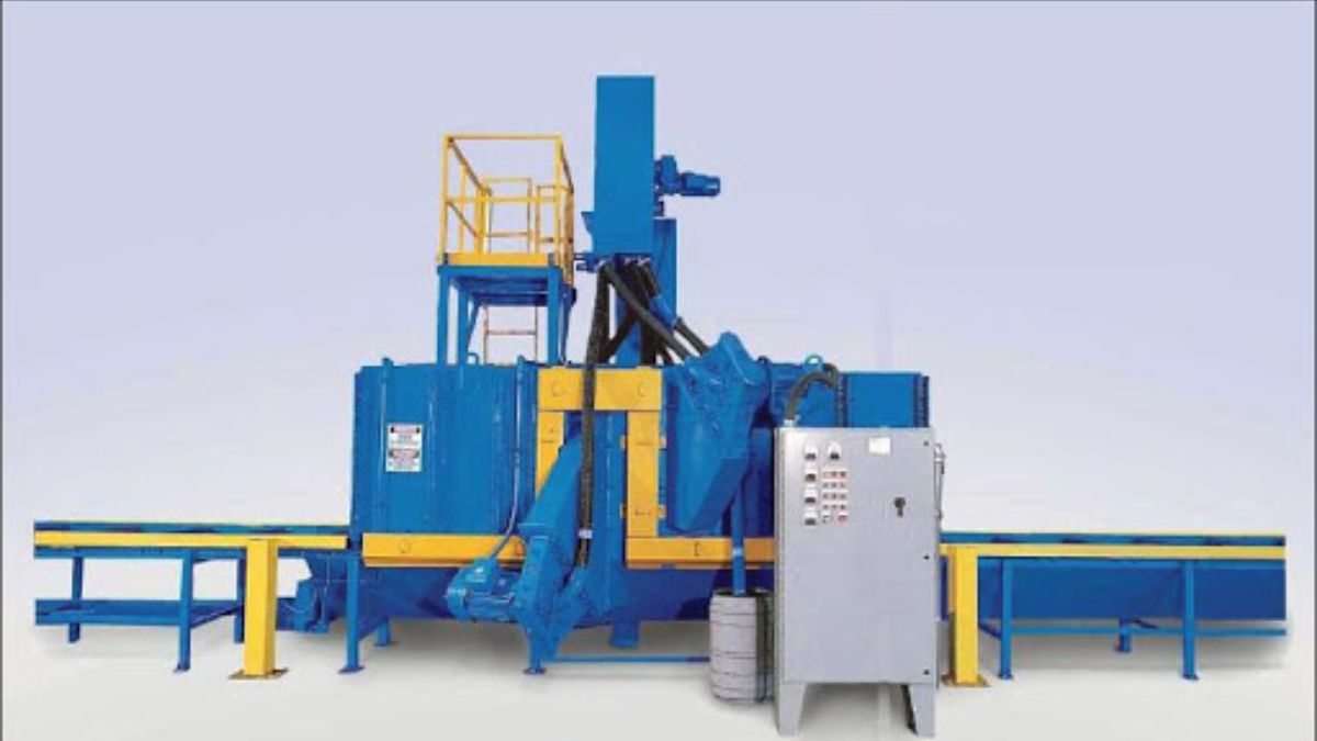 "Hình ảnh máy phun bi công nghiệp tự động màu xanh vàng, thiết kế hiện đại với băng tải, chuyên dùng làm sạch và xử lý bề mặt kết cấu thép trong ngành cơ khí."