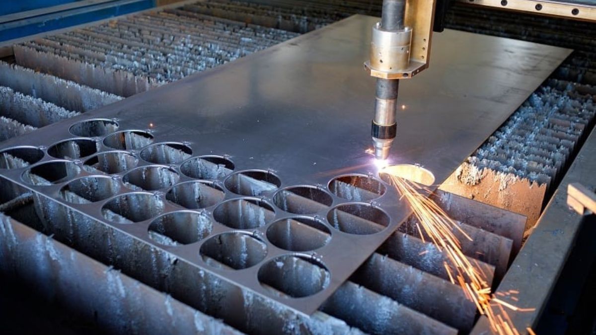 "Máy cắt plasma CNC công nghiệp đang cắt tấm thép dày với đường cắt tròn chính xác và tia lửa sáng"