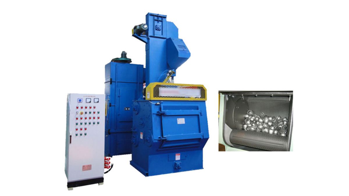 "Hình ảnh máy phun bi lồng quay công nghiệp màu xanh, đi kèm tủ điều khiển, chuyên dùng làm sạch bề mặt kim loại và chi tiết đúc trong ngành cơ khí."