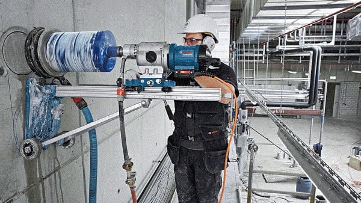 "Thợ xây dựng sử dụng máy khoan rút lõi bê tông chuyên dụng gắn tường, đảm bảo độ chính xác cao trong thi công công trình."