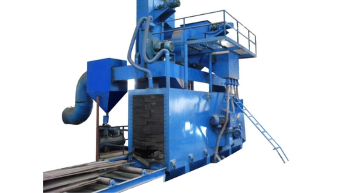 "Hình ảnh máy phun bi làm sạch bề mặt thép dạng băng tải, thiết bị công nghiệp xử lý rỉ sét và tạp chất, giúp chuẩn bị bề mặt kết cấu thép trước khi sơn phủ."