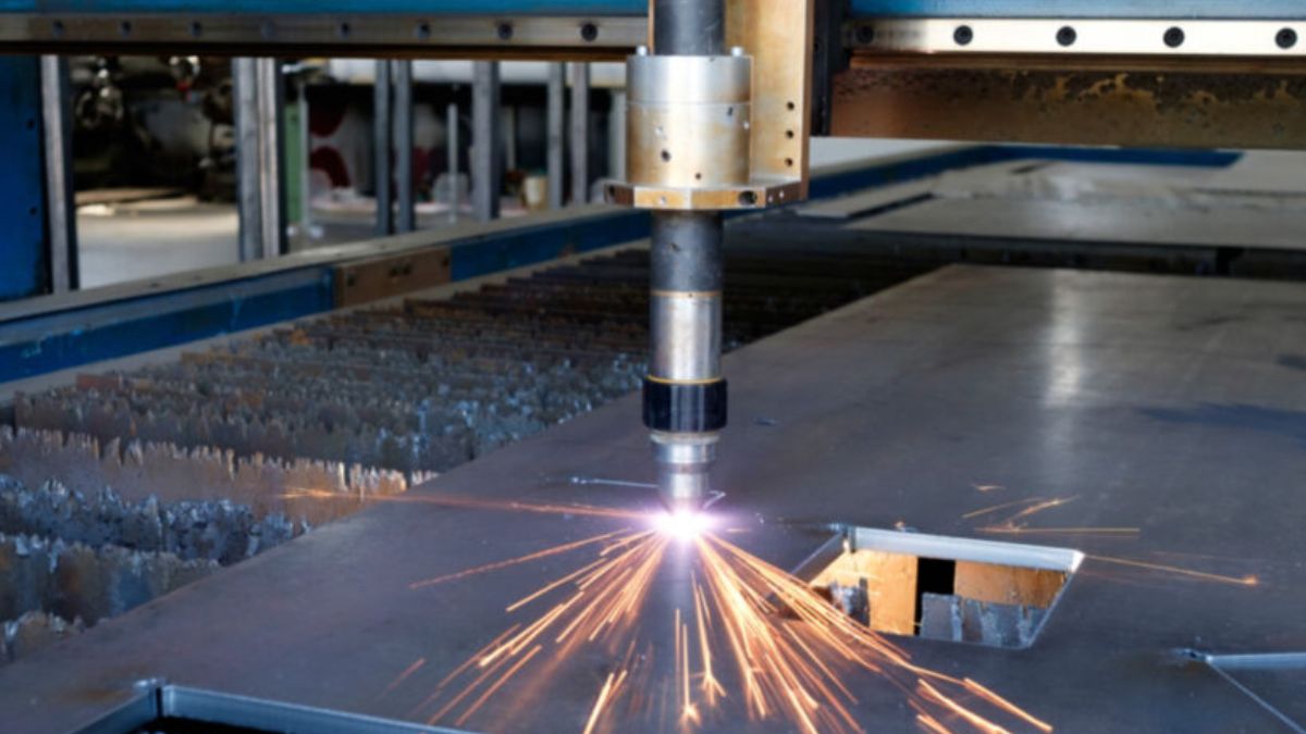 "Máy cắt plasma CNC công nghiệp đang cắt tấm thép dày với tia plasma tạo ra tia lửa sáng"