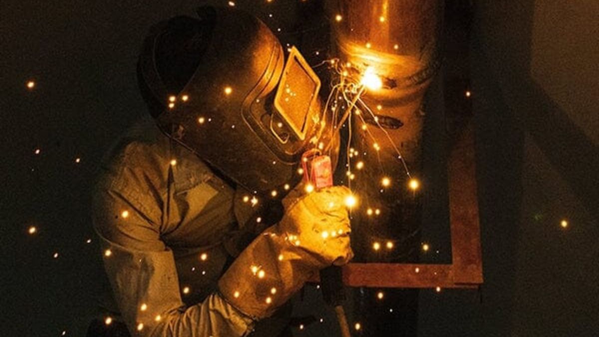 "Thợ hàn thực hiện kỹ thuật hàn 6G trên ống thép với tia lửa điện sáng, minh họa vị trí hàn nâng cao trong ngành cơ khí"