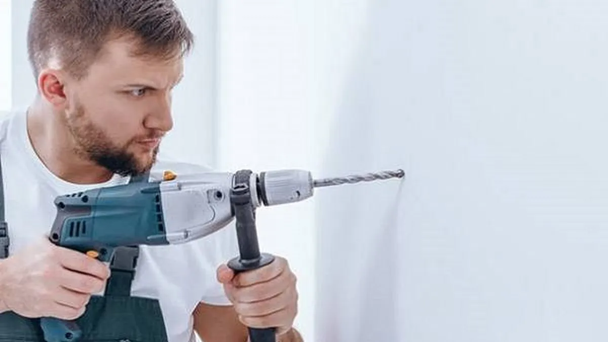 Người thợ sử dụng máy khoan búa khoan tường